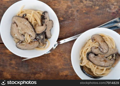 Italian spaghetti pasta and fresh wild mushrooms on rustic wood table