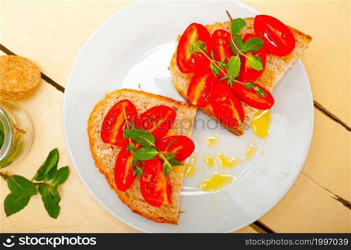 Italian tomato bruschetta with thyme and mint leaves