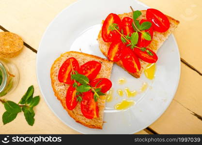 Italian tomato bruschetta with thyme and mint leaves