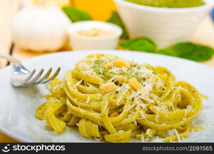 Italian traditional basil pesto pasta ingredients parmesan cheese pine nuts extra virgin olive oil garlic on a rustic table