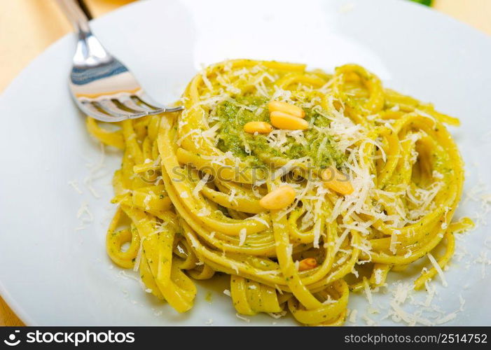 Italian traditional basil pesto pasta ingredients parmesan cheese pine nuts extra virgin olive oil garlic on a rustic table