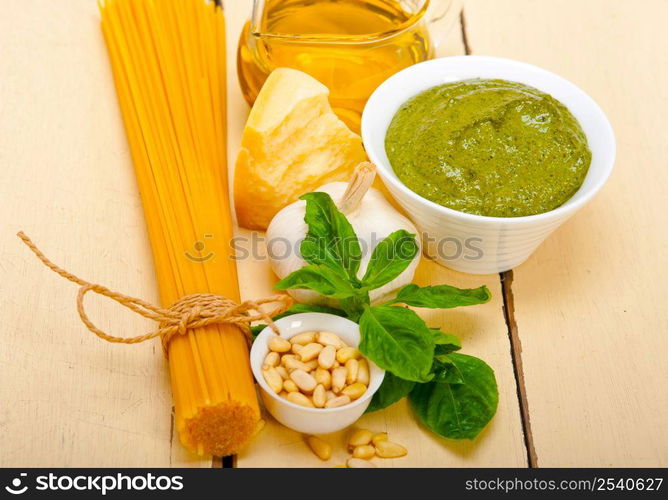 Italian traditional basil pesto pasta ingredients parmesan cheese pine nuts extra virgin olive oil garlic on a rustic table