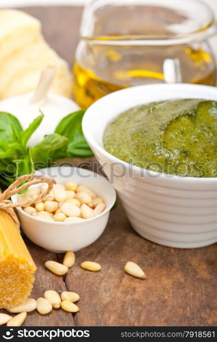 Italian traditional basil pesto pasta ingredients parmesan cheese pine nuts extra virgin olive oil garlic on a rustic table