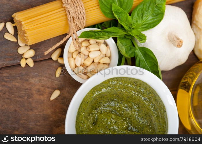 Italian traditional basil pesto pasta ingredients parmesan cheese pine nuts extra virgin olive oil garlic on a rustic table