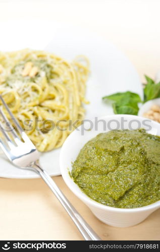 Italian traditional basil pesto pasta ingredients parmesan cheese pine nuts extra virgin olive oil garlic on a rustic table