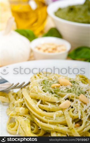 Italian traditional basil pesto pasta ingredients parmesan cheese pine nuts extra virgin olive oil garlic on a rustic table
