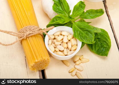 Italian traditional basil pesto pasta ingredients parmesan cheese pine nuts extra virgin olive oil garlic on a rustic table