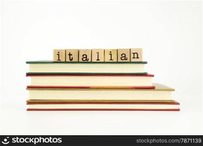 italian word on wood stamps stack on books, foreign language and translation concept