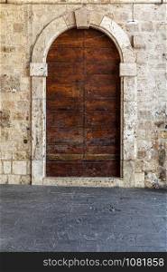 Italy: Old door on medieval stone wall