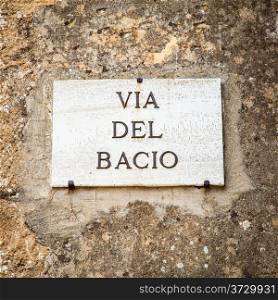 Italy - Pienza town. The streetsign of Via del Bacio (Kiss Street)