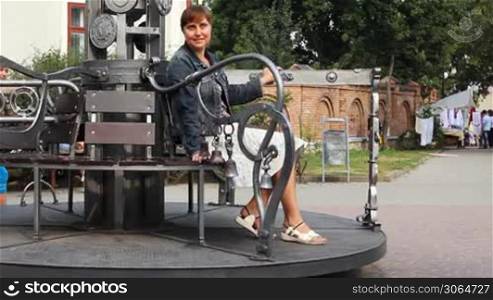 IVANO-FRANKIVSK, UKRAINE - AUGUST 11: Nice girl rotates carousel Twisting Forging Cities with her mother on August 11, 2011 in Ukraine, Ivano-Frankivsk. Carousel made blacksmith on Art Festival 2010
