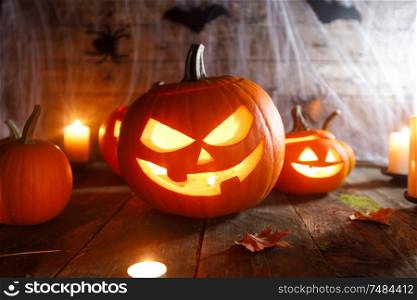 Jack O Lantern Halloween pumpkin, bats on web and burning candles. Halloween pumpkin and bats