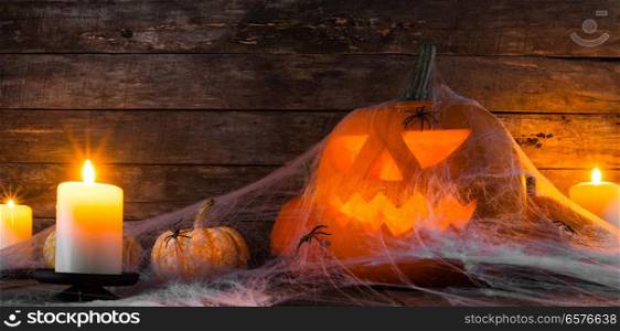 Jack O Lantern Halloween pumpkin, spiders on web and burning candles. Halloween pumpkin and spiders