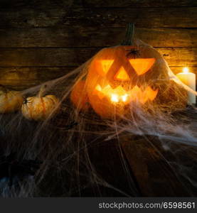 Jack O Lantern Halloween pumpkin , spiders on web and burning candles. Halloween pumpkin and spiders