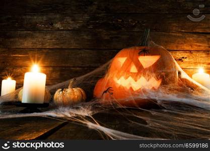 Jack O Lantern Halloween pumpkin , spiders on web and burning candles. Halloween pumpkin and spiders