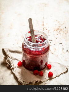 Jam from wild raspberries in the jar. On rustic background .. Jam from wild raspberries in the jar.