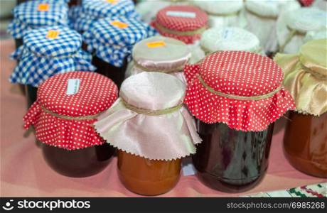 Jam in jars covered with fabric in the view
