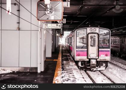 JAN 21, 2014 Hirosaki, Aomori, Japan : Pink strip JR East 701 Series commutor train at Hirosaki Station in winter, EMU train opperated on Ou Main Line between Akita and Aomori