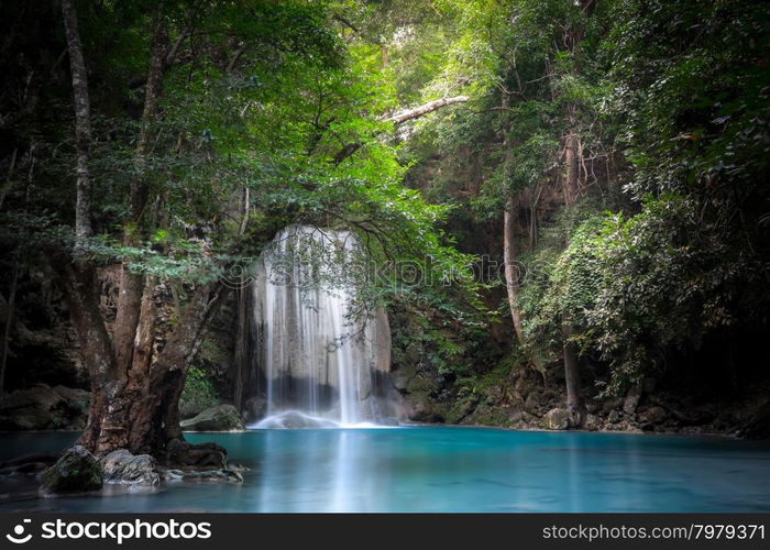 Jangle landscape with flowing turquoise water of Erawan cascade waterfall at deep tropical rain forest. National Park Kanchanaburi, Thailand