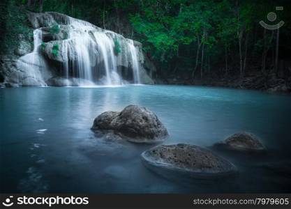 Jangle landscape with flowing turquoise water of Erawan cascade waterfall at deep tropical rain forest. National Park Kanchanaburi, Thailand