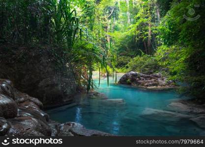 Jangle landscape with flowing turquoise water of Erawan cascade waterfall at deep tropical rain forest. National Park Kanchanaburi, Thailand