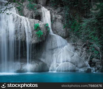 Jangle landscape with flowing turquoise water of Erawan cascade waterfall at deep tropical rain forest. National Park Kanchanaburi, Thailand