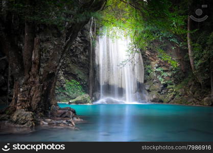 Jangle landscape with flowing turquoise water of Erawan cascade waterfall at deep tropical rain forest. National Park Kanchanaburi, Thailand