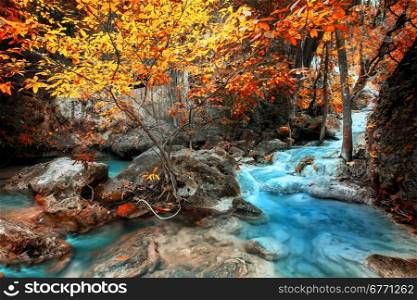 Jangle landscape with flowing turquoise water of Erawan waterfall at deep tropical rain forest. National Park Kanchanaburi, Thailand