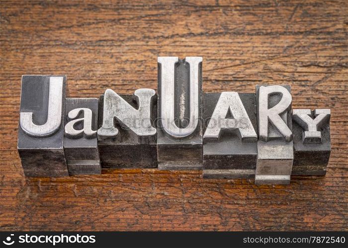 January word in mixed vintage metal type printing blocks over grunge wood