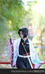 Japan anime cosplay portrait of girl with comic costume with japanese theme garden