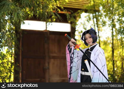 Japan anime cosplay portrait of girl with comic costume with japanese theme garden