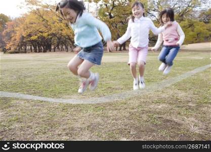 Japanese children skip a rope in the park