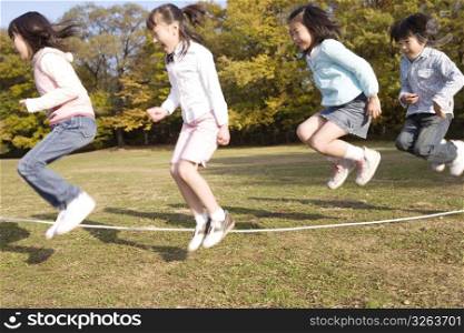Japanese children skip a rope in the park