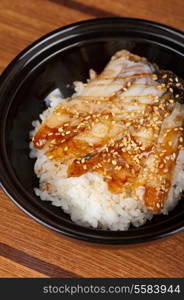 Japanese cuisine, eel with rice at black plate