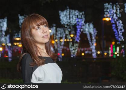 Japanese female outside with volorful lights in background