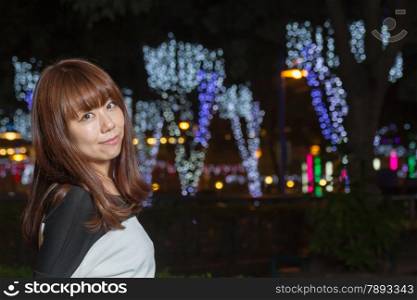 Japanese female outside with volorful lights in background