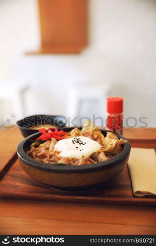 Japanese food Gyudon Japanese beef on rice bowl topped with egg on wooden table