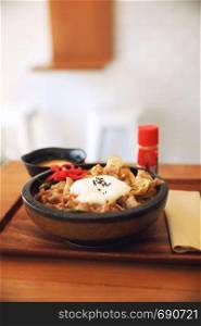 Japanese food Gyudon Japanese beef on rice bowl topped with egg on wooden table