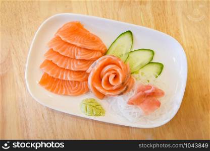 Japanese food raw sashimi salmon fillet with vegetable cucumber and wasabi in the restaurant / Salmon sashimi menu set Japanese cuisine fresh ingredients on plate , selective focus