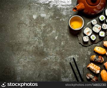 Japanese food. Sushi rolls and a Cup of tea. On the stone table.. Japanese food. Sushi rolls and a Cup of tea.