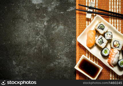 Japanese food . The rolls and sushi with soy sauce on bamboo stand.. The rolls and sushi with soy sauce on bamboo stand.