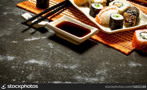Japanese food . The rolls and sushi with soy sauce on bamboo stand.. The rolls and sushi with soy sauce on bamboo stand.