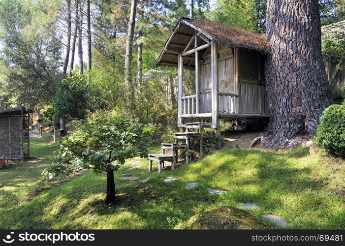 Japanese garden with a bamboo hut on a sloping land