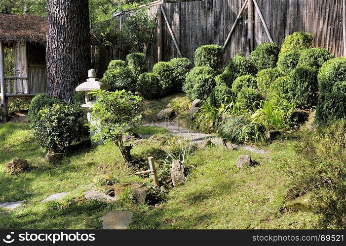 Japanese garden with a bamboo hut on a sloping land