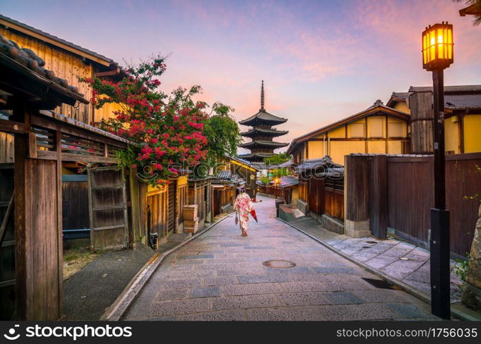 Japanese girl in Yukata with red umbrella in old town Kyoto, Japan