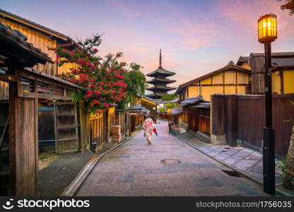 Japanese girl in Yukata with red umbrella in old town Kyoto, Japan