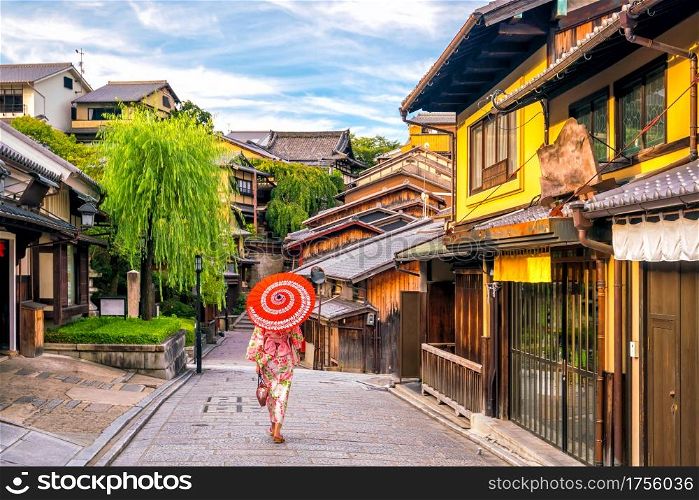 Japanese girl in Yukata with red umbrella in old town Kyoto, Japan