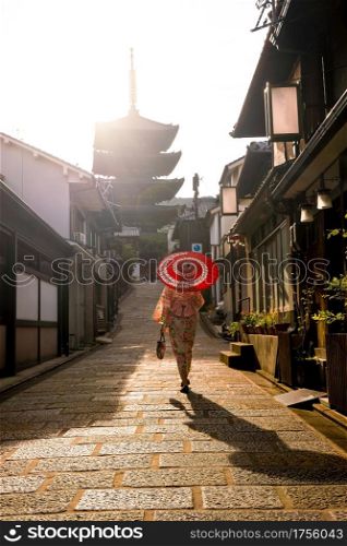Japanese girl in Yukata with red umbrella in old town Kyoto, Japan
