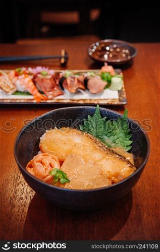 Japanese grilled snow fish Donburi rice bowl and mix premium sushi on wood table in restaurant