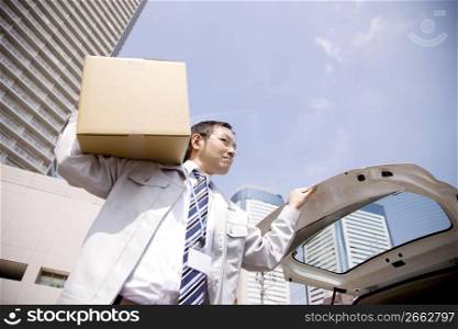 Japanese office worker carrying corrugated cardboard